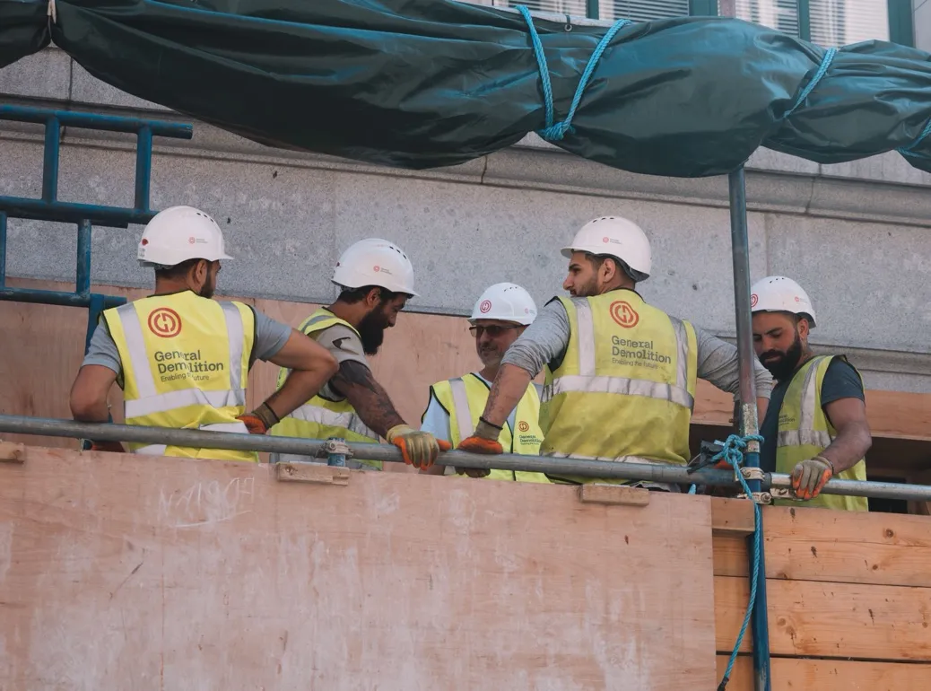Construction workers in hard hats and hi-vis vests on site